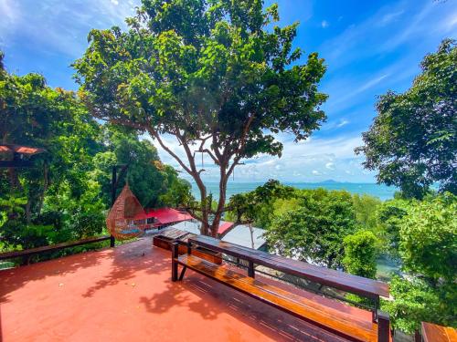 a wooden bench sitting on top of a building with a tree at Rapala Rock Wood Resort- SHA Plus in Railay Beach