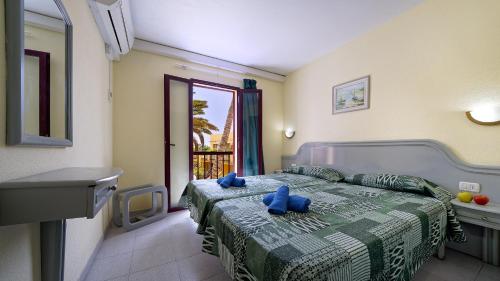 Tempat tidur dalam kamar di Bungalows Maspalomas Oasis Club - All Inclusive.