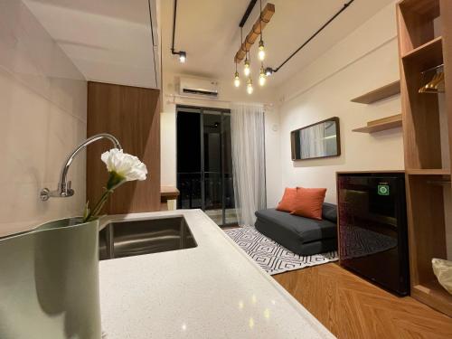 a kitchen and living room with a sink and a couch at lalerooms Warm and cozy Studio at Skyhouse BSD find us on ig lalerooms in Tangerang