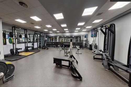 a gym with several rows of treadmills and machines at Village Hotel Leeds North in Leeds