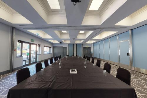 a large conference room with a long table and chairs at Village Hotel Leeds North in Leeds