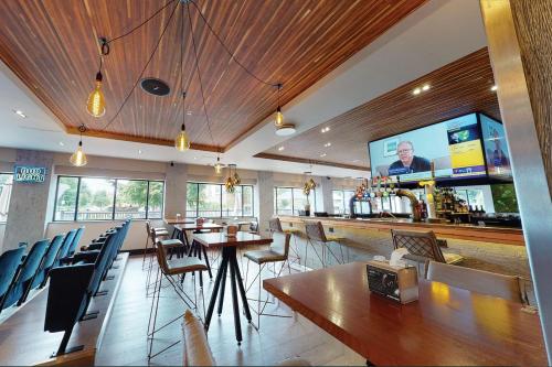a bar in a restaurant with chairs and a counter at Village Hotel Leeds North in Leeds