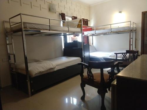 two bunk beds in a room with a desk and a chair at Hotel Persona International in New Delhi