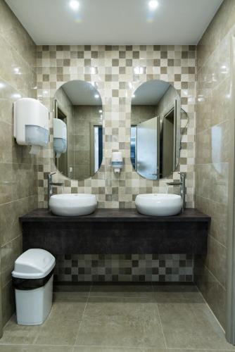 a bathroom with two sinks and two mirrors at Hotel Euforia Lounge in Šabac