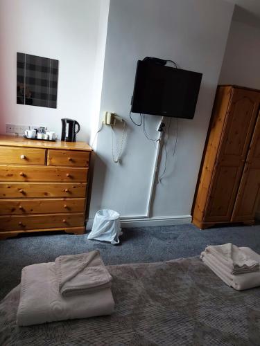 a bedroom with a bed and a tv and a dresser at Ambrose Hotel in Barrow in Furness