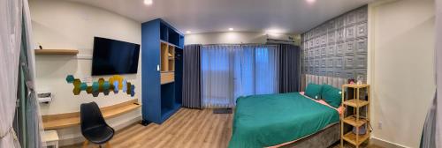 um quarto com uma cama verde e uma televisão em Căn hộ cao cấp chung cư Gateway Vũng Tàu em Vung Tau