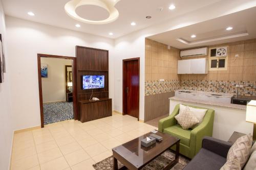كيان للأجنحة الفندقية في خميس مشيط: غرفة معيشة مع أريكة وطاولة وتلفزيون