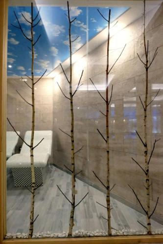 a room with trees in a window with a couch at L&N Apartmani Kopaonik-Milmari Resort in Kopaonik