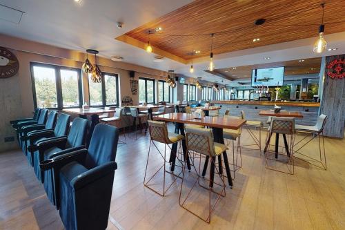 a restaurant with chairs and tables and a bar at Village Hotel Coventry in Coventry