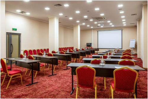 a conference room with tables and chairs and a whiteboard at Ani Grand Hotel Yerevan in Yerevan