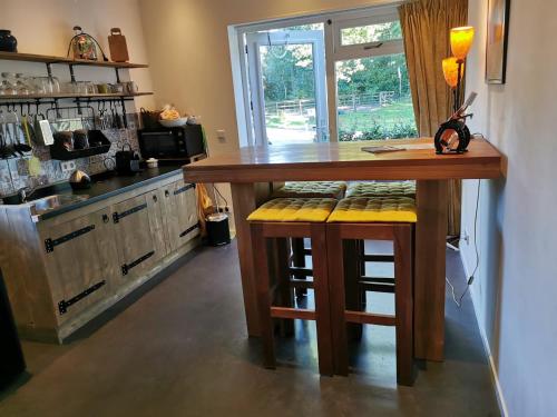 a kitchen with a wooden table and stools at Erve Het Roolvink Boerderij Appartementen 40-50 M2 in Enschede