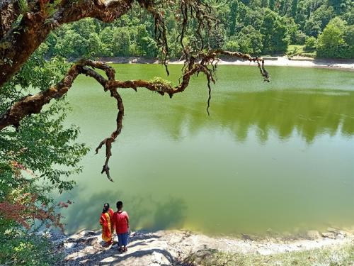 a group of three people standing near a lake at SAMAUN Homestay in Kurchhola