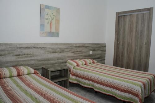 a room with two beds and a painting on the wall at Pensión Pardo in Benidorm