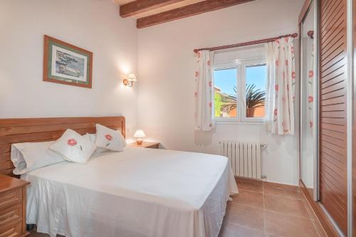 a bedroom with a white bed and a window at Villa Can Tomeu in Felanitx