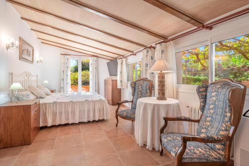 een slaapkamer met een bed en een tafel en stoelen bij Villa Can Tomeu in Felanitx
