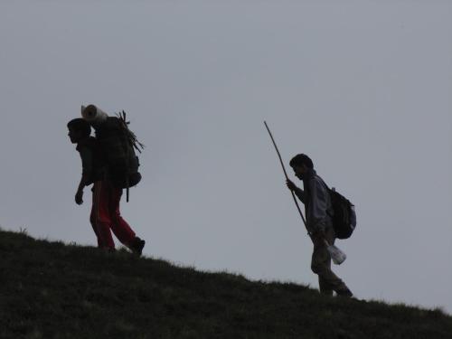 two people walking up a hill with backpacks at SAMAUN Homestay in Kurchhola