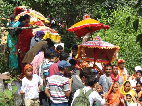 a crowd of people walking down a street with an elephant at SAMAUN Homestay in Kurchhola