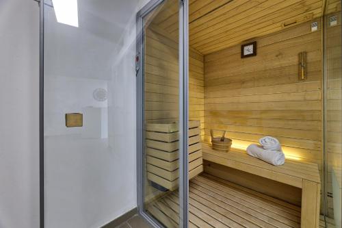 a sauna with a wooden floor and a glass door at Hotel THB Flora in Puerto del Carmen
