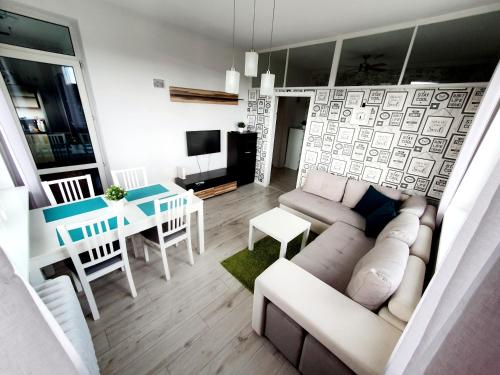 een woonkamer met een bank en een tafel bij Apartament GOOD POINT - RYBAKI Gdańsk in Gdańsk