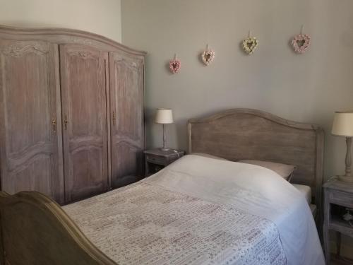 een slaapkamer met een bed, houten meubels en 2 lampen bij Joli T2 de 40m² à louer à Le Muy (83490) in Le Muy