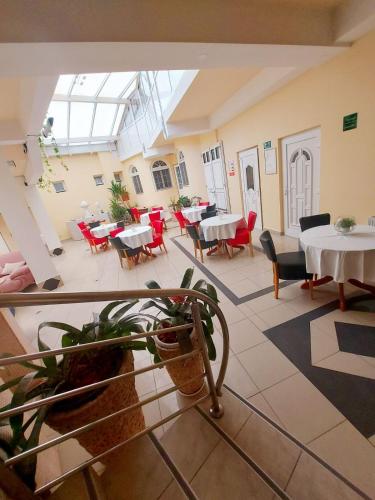 a large room with tables and chairs in a building at Hotel Villa Valpovo in Valpovo