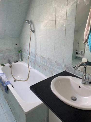 Nandy的住宿－CHAMBRE de LUXE，浴室配有盥洗盆和浴缸。