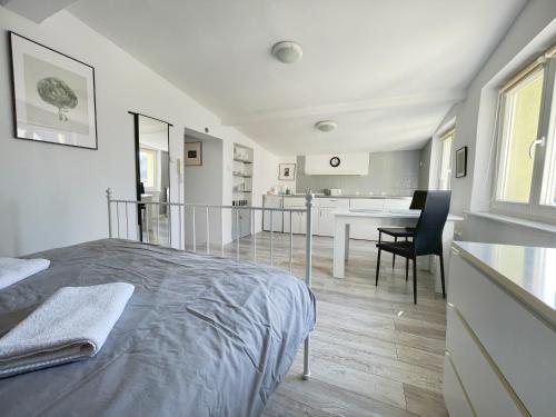 Ein weißes Zimmer mit einem Bett und einem Esszimmer. in der Unterkunft Apartament Dotyk - Monte Cassino- Kameralne Poddasze in Sopot