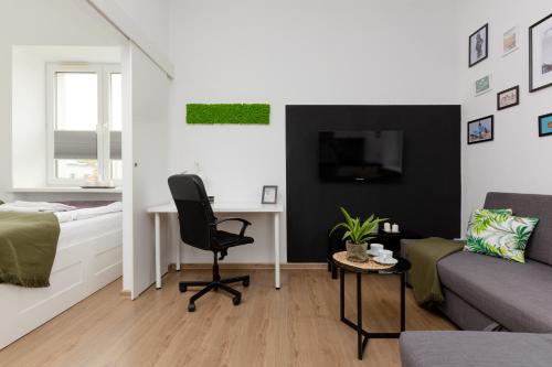 a bedroom with a bed and a desk and a chair at Metro Młynów Warsaw Wola Apartment Długosza by Renters in Warsaw