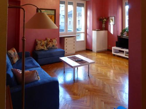 Casa Clemente in Cit Turin في تورينو: غرفة معيشة مع أريكة زرقاء وطاولة