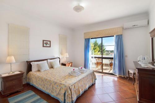 een slaapkamer met een bed en een raam met uitzicht bij Casa da Alfarrobeira in Loulé