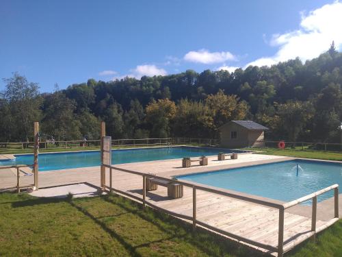 een groot zwembad met een houten terras bij Cabañas Peumayen Vilches in Vilches