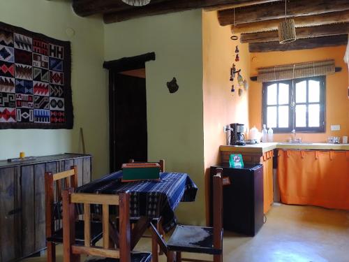 a kitchen with a table and a kitchen with a refrigerator at Los Amarantos in Tilcara
