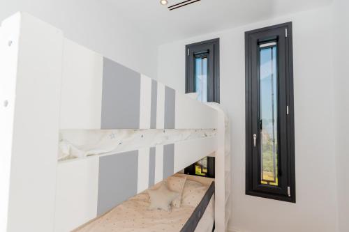 eine Treppe in einem weißen Zimmer mit 2 Fenstern in der Unterkunft Cubo's Villa Elena in Alhaurín el Grande