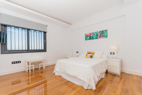 ein weißes Schlafzimmer mit einem Bett und einem Fenster in der Unterkunft Cubo's Villa Elena in Alhaurín el Grande