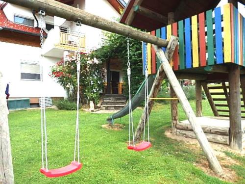 a playground with swings in a yard at Ferienwohnung Silvia in Sankt Kanzian