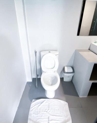 a bathroom with a white toilet and a sink at The Seacret Kohlarn in Ko Larn