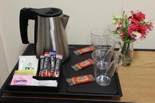 ein Tablett mit einer Kaffeekanne und Gläsern auf dem Tisch in der Unterkunft Hazeldean in Manchester