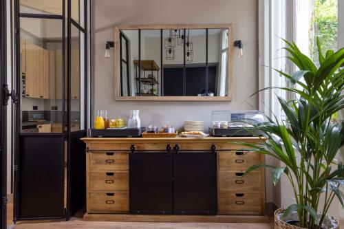 a kitchen with a mirror and a wooden dresser at Hôtel Le Fer à Cheval in Trouville-sur-Mer