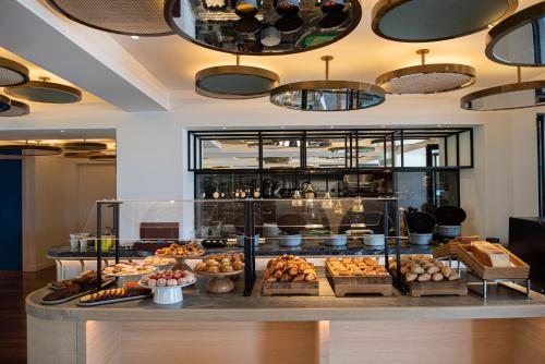 a bakery with many different types of pastries on display at Athens Capital Center Hotel - MGallery Collection in Athens
