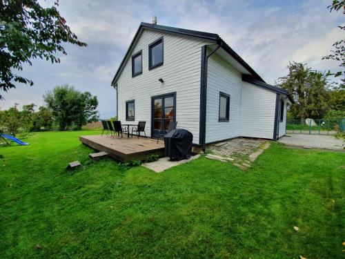 a white house with a porch and a wooden deck at Czech Paradise Village in Jenschowitz