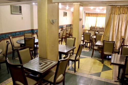 um restaurante com mesas e cadeiras num quarto em Sea Star em Alexandria