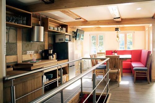 Habitación con cocina con sillas rojas y mesa. en Ferienhaus Schloßblick, en Quedlinburg