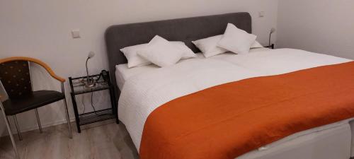 a bedroom with a bed with an orange and white blanket at Am Meilenstein in Limburg an der Lahn