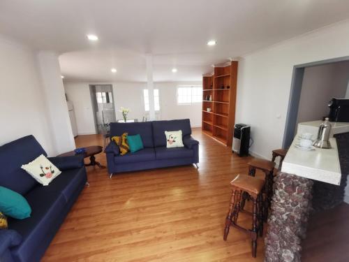a living room with two blue couches and a table at Casa do Curral Velho in Santana
