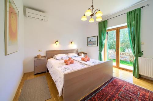 a bedroom with a bed and a large window at Villa Maria in Sužan