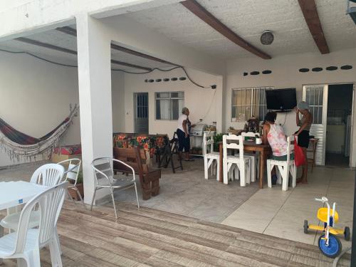 two people sitting at a table in a living room at Pousadinha da Lulu - Pontal Mangue Seco in Indiaroba