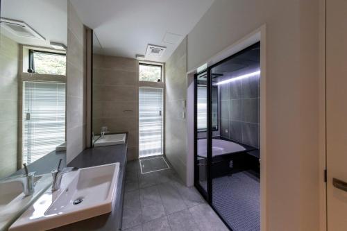 ein Badezimmer mit Waschbecken, Badewanne und Dusche in der Unterkunft GLテラス in Kyonan