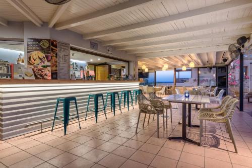 a restaurant with chairs and tables and a bar at Ida Village in Hersonissos