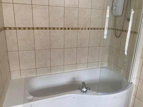 a bath tub with a faucet in a bathroom at The George Hotel in Castle Cary