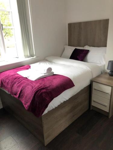 una cama con un osito de peluche sentado encima en Luxury Lavish Studio Apartments LE1, en Leicester